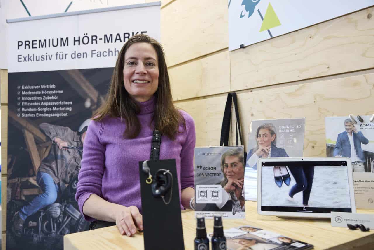 Auf der internationalen Leitmesse für Optik und Design (hier zu sehen: Janin Schmelzer von Optimus Hearing auf der opti 2025) war die Hörakustik bislang bereits punktuell vertreten. Ab 2026 soll das Thema wesentlich sichtbarer werden.